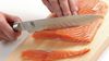 
                    Scalloped slicing knife in use while cutting salmon