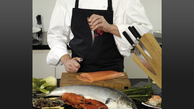 
                    Le couteau à jambon flexible coupe finement le saumon.